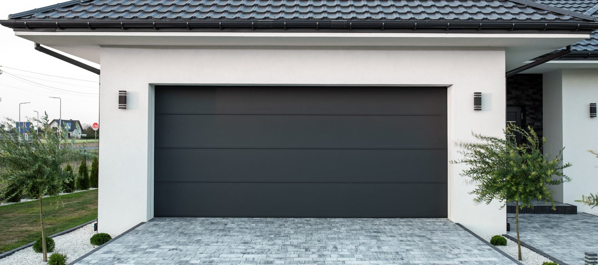Modern garage door with paved driveway.